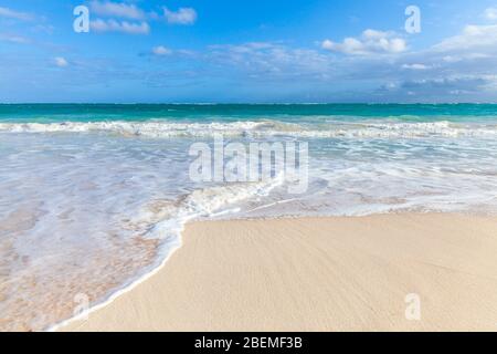 Karibische Küstenlandschaft mit sandiger Küste und Meereswellen. Atlantikküste, Dominikanische republik. Bavaro Strand Stockfoto