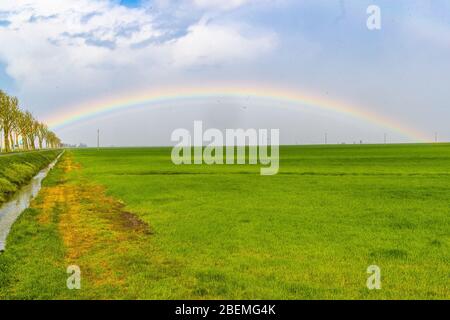 Jolanda di Savoia, Italien. 14 April 2020. Regenbogen nach einem Sturm in Jolanda di Savoia, Italien. Kredit: Filippo Rubin / Alamy Stockfoto