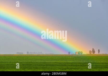 Jolanda di Savoia, Italien. 14 April 2020. Regenbogen nach einem Sturm in Jolanda di Savoia, Italien. Kredit: Filippo Rubin / Alamy Stockfoto