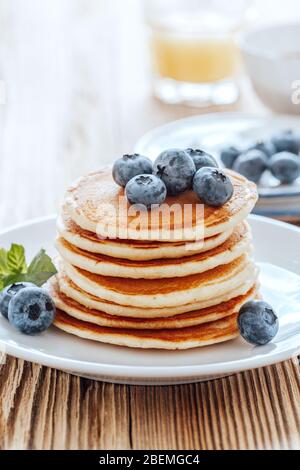 Gesundes vegetarisches Frühstück oder Brunch, Lieblingsgericht. Hausgemachte Pfannkuchen, frische Sommerbeeren, Kaffee und Saft auf Holztisch Stockfoto