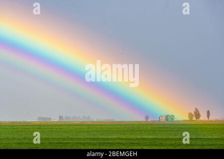 Jolanda di Savoia, Italien. 14 April 2020. Regenbogen nach einem Sturm in Jolanda di Savoia, Italien. Kredit: Filippo Rubin / Alamy Stockfoto