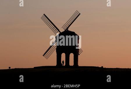 Chesterton, Warwickshire, Großbritannien. April 2020. Wetter in Großbritannien. Ein Mann beobachtet den Sonnenuntergang unter der Chesterton Windmill während der Sperrung der Coronavirus-Pandemie. Credit Darren Staples/Alamy Live News. Stockfoto