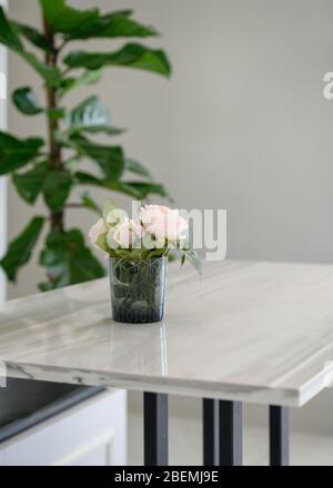 Rosa Rose blüht in Glas auf Holztisch Stockfoto