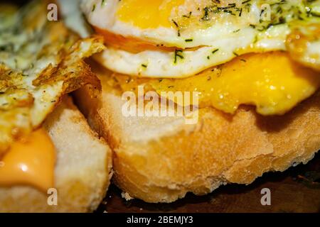 Sandwiches mit Spiegeleiern mit Dill und Soße auf Weizenbrot. Nahaufnahme Stockfoto