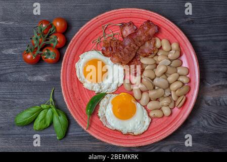 Bauernmahlzeiten Bohneneier Speck Tomaten Basilikum Kirsche Tomaten Draufsicht Stockfoto