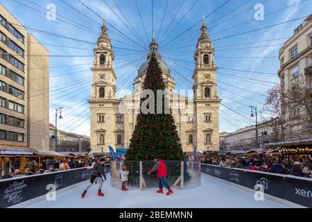 Schlittschuhlaufen auf einer Eisbahn vor der St. Stephens Basilika, Budapest Stockfoto