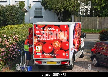 Ein Tesco Lieferfahrer und Van liefern Lebensmittel in einen Haushalt Stockfoto