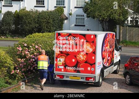 Ein Tesco Lieferfahrer und Van liefern Lebensmittel in einen Haushalt Stockfoto