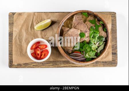 Vietnamesische Nudelsuppe Pho bo mit Limette, Chili, Zwiebel, rohem Gemüse. Draufsicht Stockfoto