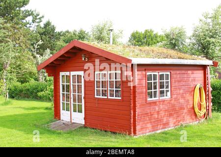 Rote Holzhütte im Garten Stockfoto