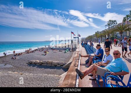 Menschen, die die Sonne an der Promenade des Anglais in Nizza, Frankreich, Europa genießen Stockfoto