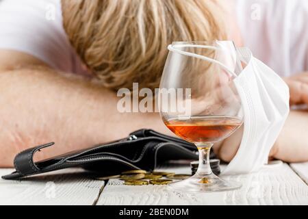 Verzweifelter Mensch fällt in Depression und wird alkoholisch und elend. Seine sucht führt ihn in einen Zustand der Einsamkeit und Armut Stockfoto