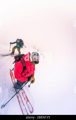 Zwei Leute, die im Nebel auf dem Gipfel ankommen Stockfoto