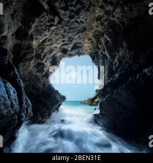 Pacific Waves Crash durch eine Meereshöhle im Leo Carillo State Park Stockfoto