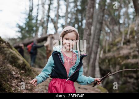 Porträt eines jungen Mädchens, das einen Stock hält, während er in Schweden wandert Stockfoto