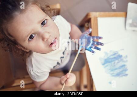 Kinder spielen in einem Innenhof und malen mit Wasserfarben Stockfoto