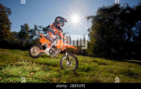 12-jähriger Junge springt mit seinem Off-Road-Motorrad Stockfoto