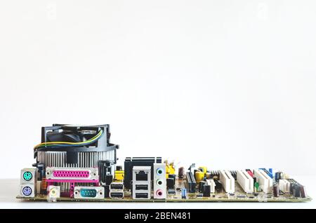 Nahaufnahme der Vorderansicht eines zerlegten Mainboards auf weißem Hintergrund. Elektronische Geräte bereit für die Reparatur Stockfoto