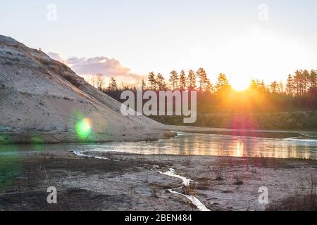 Natürlicher Sonnenuntergang vor dem Hintergrund der Wälder. Stockfoto