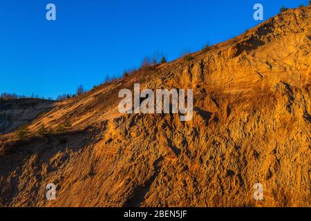 Sandiger Berg gegen den blauen wolkenlosen Himmel. Stockfoto