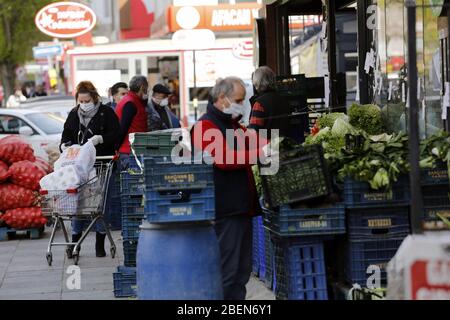 Ankara, Türkei. April 2020. Menschen mit Gesichtsmasken kaufen auf einem Markt in Ankara, Türkei, 14. April 2020 ein. Der türkische Gesundheitsminister Fahrettin Koca bestätigte am Dienstag 4,062 neue COVID-19-Fälle und 107 weitere Todesfälle durch das Virus. Die Gesamtzahl der bestätigten COVID-19-Fälle in der Türkei stieg auf 65,111, während die Zahl der Todesopfer auf 1,403 stieg, sagte Koca auf einer Pressekonferenz. Kredit: Mustafa Kaya/Xinhua/Alamy Live News Stockfoto