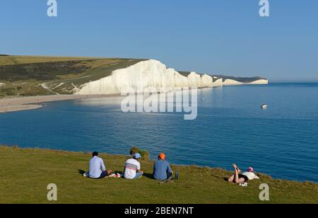 Eine Gruppe junger Menschen genießt die berühmten Seven Sisters Cliffs in Sussex vom Seaford Head Nature Reserve, East Sussex, Großbritannien Stockfoto