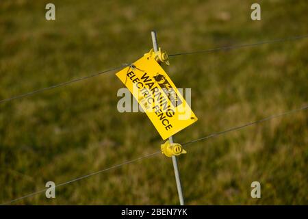 Warnschild an einem elektrischen Viehzaun am South Downs Way auf den Seven Sisters Hills und Klippen in East Sussex, Großbritannien Stockfoto