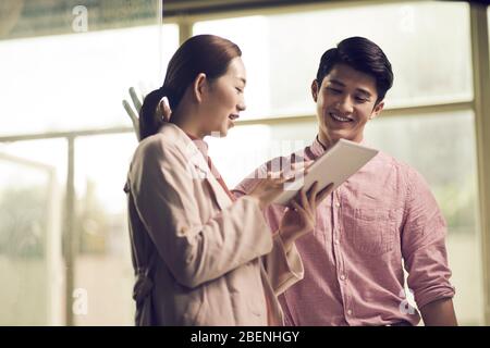 asiatische Geschäftsleute treffen sich im Büro und diskutieren mit einem digitalen Tablet Stockfoto