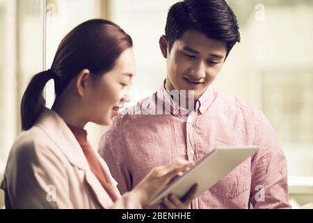 asiatische Geschäftsleute treffen sich im Büro und diskutieren mit einem digitalen Tablet Stockfoto