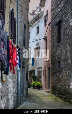 Buzet, Istrien / Kroatien - 16. Juni 2013: Eine schmale, traditionelle Gasse im Zentrum der Altstadt, mit drahtgetrockneter Wäsche an der Hauswand Stockfoto