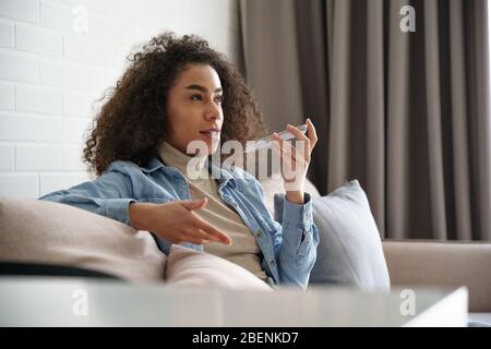 African girl mit virtuellen digitalen Sprachassistenten auf Handy-App. Stockfoto