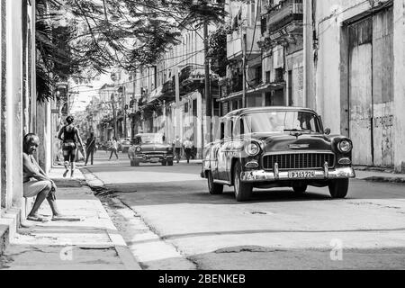 Eine Frau sitzt auf ihrer Türe und sieht die Welt an ihr vorbei im Cento Havana, Kuba im November 2015. Stockfoto