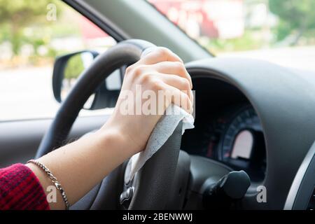 Frauen Fahrer desinfizieren Lenkrad in Mietwagen von Car Sharing bei Covid-19 Coronavirus Epidemie Stockfoto