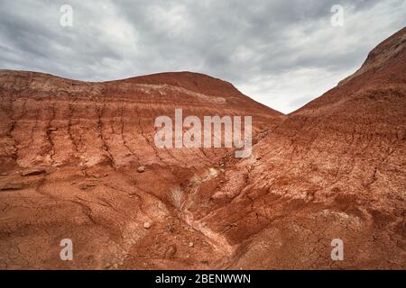 Rot gestreifte Berge bei bedecktem Himmel im Desert Park Altyn Emel in Kasachstan Stockfoto