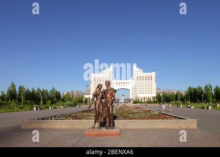 NUR-SULTAN, ASTANA, KASACHSTAN - 3. JUNI 2015: Bronzestatue des Mädchens und Jungen, die vor KazMunayGas, dem staatlichen Öl- und Gasunternehmen, srasen Stockfoto