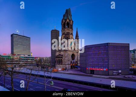 11. April 2020, Berlin, Kaiser-Wilhelm-Gedächtniskirche am Breitscheidplatz/Kurfürstendamm in Berlin Charlottenburg. Die Gedächtniskirche ist ein Ensemble aus dem alten Kirchturm (Turmruine), der im Zweiten Weltkrieg stark beschädigt wurde, im Stil der Neoromantik erbaut und später als Mahnmal gegen den Krieg, dem neuen Kirchturm und dem neuen Kirchenschiff hinterlassen wurde. In Berlin werden letztere aufgrund der modernen, achteckigen Architektur "Lippenstift und Puderdose" manchmal auch "Hohler Zahn" genannt. Weltweit verwendet Stockfoto