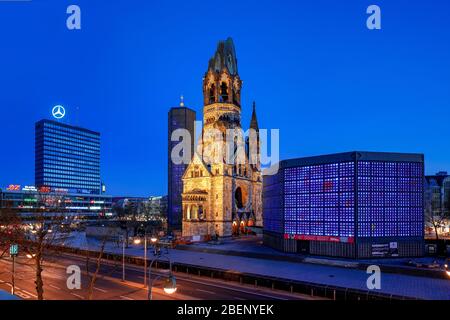 11. April 2020, Berlin, Kaiser-Wilhelm-Gedächtniskirche am Breitscheidplatz/Kurfürstendamm in Berlin Charlottenburg. Die Gedächtniskirche ist ein Ensemble aus dem alten Kirchturm (Turmruine), der im Zweiten Weltkrieg stark beschädigt wurde, im Stil der Neoromantik erbaut und später als Mahnmal gegen den Krieg, dem neuen Kirchturm und dem neuen Kirchenschiff hinterlassen wurde. In Berlin werden letztere aufgrund der modernen, achteckigen Architektur "Lippenstift und Puderdose" manchmal auch "Hohler Zahn" genannt. Weltweit verwendet Stockfoto