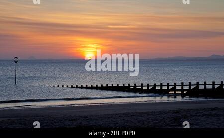 Portobello Beach, Edinburgh, Schottland, Großbritannien. April 2020. Der Sonnenaufgang über dem Firth of Forth begrüßt die Leute, während sie ihre tägliche erlaubte Bewegung bekommen. Temperatur 6 Grad bei leichter Brise. Stockfoto