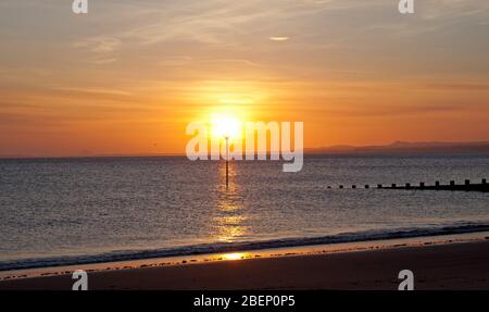 Portobello Beach, Edinburgh, Schottland, Großbritannien. April 2020. Der Sonnenaufgang über dem Firth of Forth begrüßt die Leute, während sie ihre tägliche erlaubte Bewegung bekommen. Temperatur 6 Grad bei leichter Brise. Stockfoto