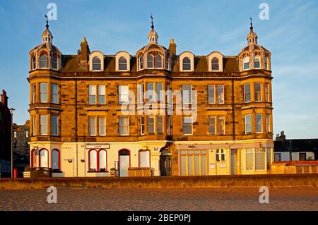 Portobello Beach, Edinburgh, Schottland, Großbritannien. April 2020. Stysh Sandsteingebäude aus dem Jahr 1877 an der Strandpromenade bei Sonnenaufgang. Unterkunft über einer Bar und einem Restaurant. Stockfoto