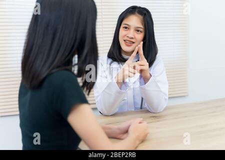 Junge asiatische Ärztin gibt Beratung und hören Erwachsene weiblichen Patienten Symptome im Büro. Patient mit Rücksprache mit Arzt in offic Stockfoto