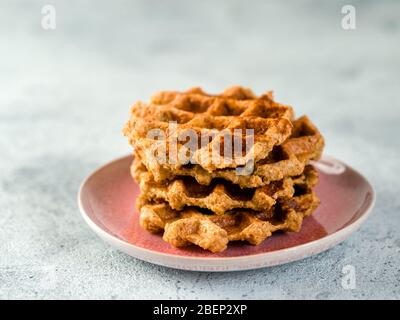 Einfache gesunde glutenfreie Haferwaffeln mit Kopierplatz. Stapel von appetitlichen hausgemachten Waffeln mit Hafermehl auf dem Teller über hellgrauen Zement Hintergrund Stockfoto