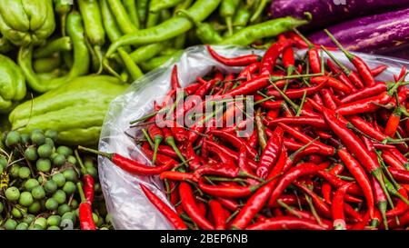 Nahaufnahme von frischem und rotem Chili und exotischen Gemüse zum Verkauf auf einem asiatischen Straßenmarkt Stockfoto
