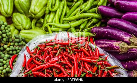 Nahaufnahme von frischem und rotem Chili und anderen exotischen Gemüse zum Verkauf auf einem asiatischen Straßenmarkt Stockfoto