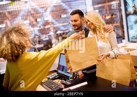 Fröhliches junges Paar beim Einkaufen in einem Bekleidungsgeschäft Stockfoto