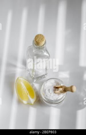 Essig, Backpulver und Zitrone auf dem hellen Hintergrund. Umweltfreundliche Zutaten für die Hausreinigung Stockfoto