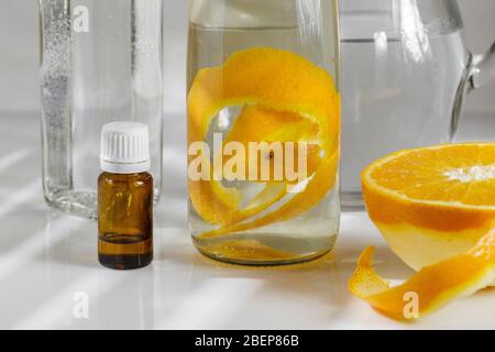 Allzweckreiniger aus natürlichen Zutaten, Weißessig, Wasser, Zitronenschale und Aromaöl. Bio-Waschmittel in einer Glasflasche Stockfoto