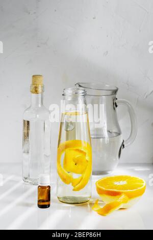 Allzweckreiniger aus natürlichen Zutaten, Weißessig, Wasser, Zitronenschale und Aromaöl. Bio-Waschmittel in einer Glasflasche Stockfoto