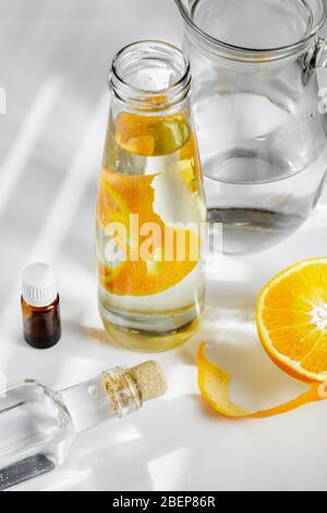 Allzweckreiniger aus natürlichen Zutaten, Weißessig, Wasser, Zitronenschale und Aromaöl. Bio-Waschmittel in einer Glasflasche Stockfoto