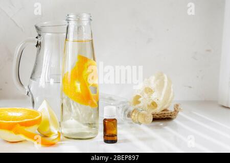 Allzweckreiniger aus natürlichen Zutaten, Weißessig, Wasser, Zitronenschale und Aromaöl. Bio-Waschmittel in einer Glasflasche. Platz für Ihr Stockfoto